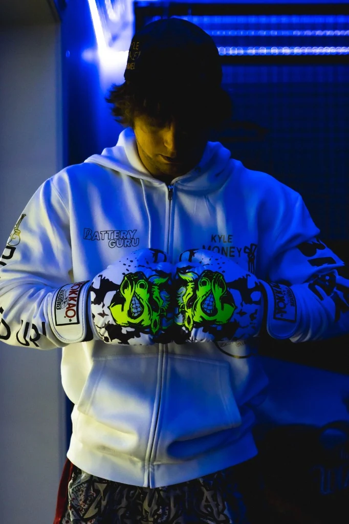 Dramatic portrait of Kyle Money Hammel in boxing gloves and Battery Guru hoodie